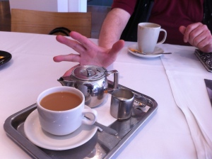 Photo of tray with tea paraphernalia and a hand in the background